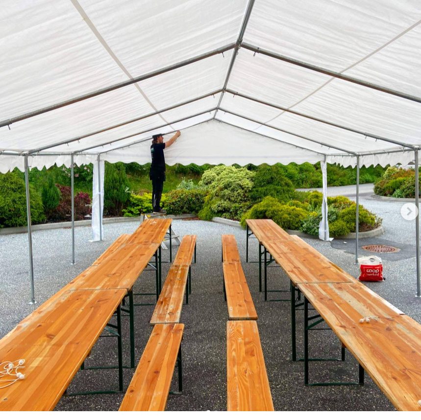 Benksett med bord og benker inne i partytelt